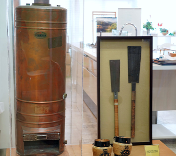 森川桶工時代に使用していたのこぎり（右）と森川商会が製造した銅製風呂釜