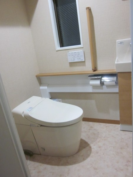 手洗い器を別に設置できるシステムトイレに。吊戸棚を取り付けて収納量を増やしました。